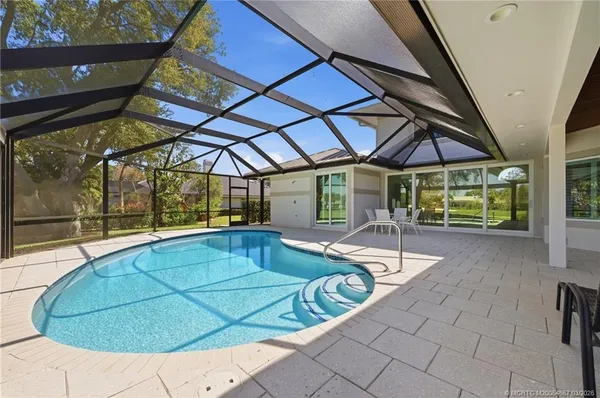 a view of a backyard with table and chairs under an umbrella