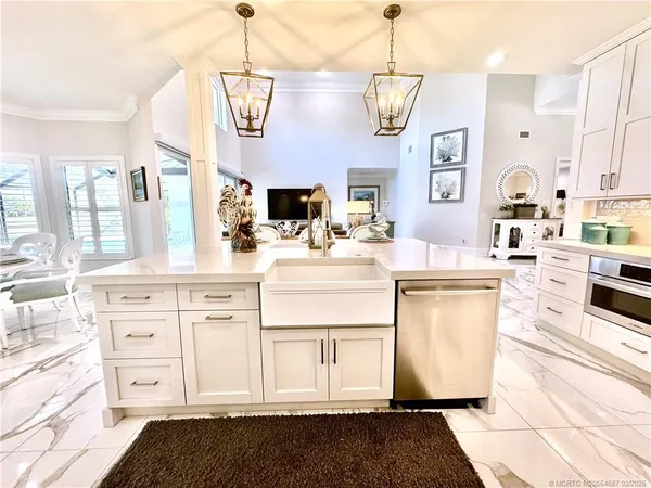 a kitchen with white cabinets and sink