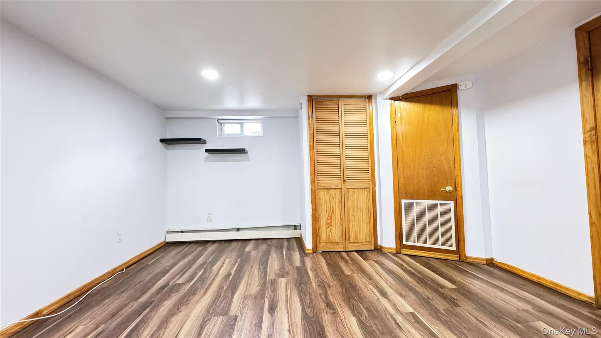 168-12 19th Avenue Queens, NY 11357 - Photo 23 of 27 Unfurnished bedroom featuring wood finished floors, baseboard heating, and recessed lighting