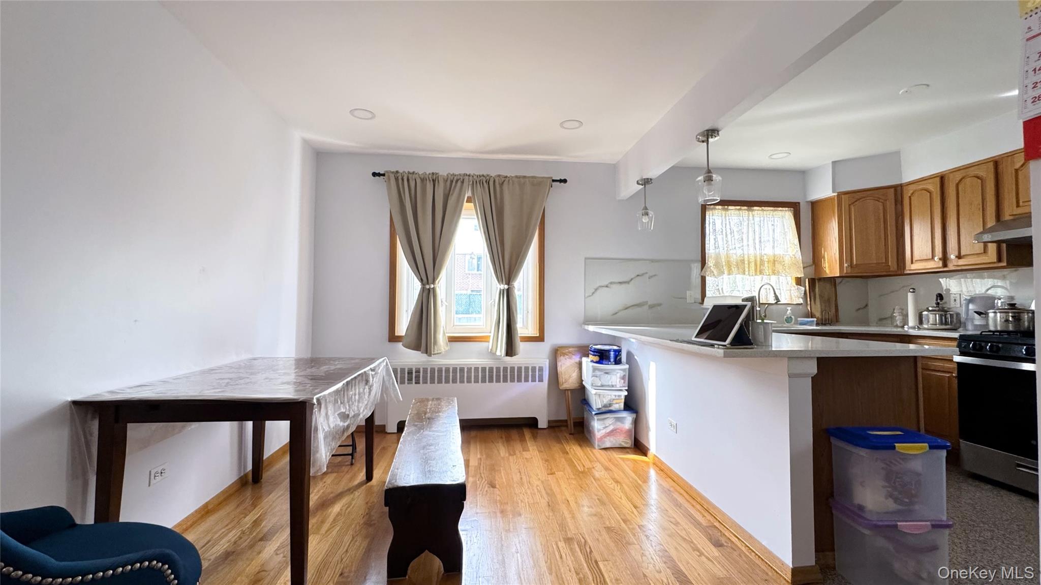 168-12 19th Avenue Queens, NY 11357 - Photo 6 of 27 Kitchen with brown cabinetry, gas range, plenty of natural light, and radiator heating unit