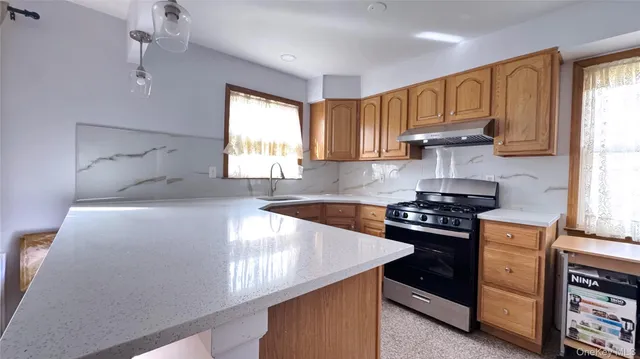a kitchen with stainless steel appliances a stove a sink and a refrigerator