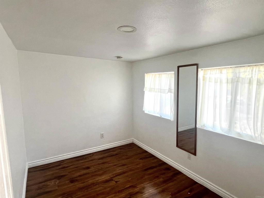 10707 Jamacha Boulevard, Unit 72 Spring Valley, CA 91978 - Photo 9 of 18 an empty room with wooden floor and windows