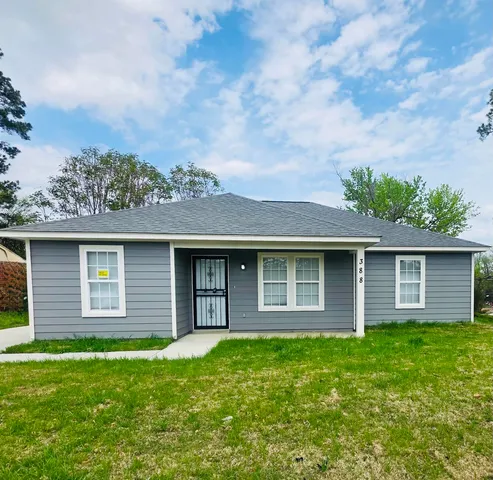 a front view of a house with a garden