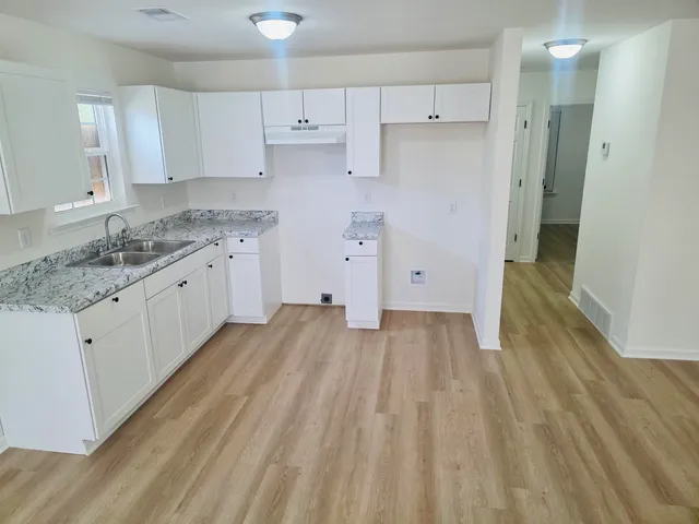 a kitchen with a sink refrigerator and cabinets