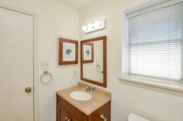 a bathroom with a granite countertop sink and a mirror