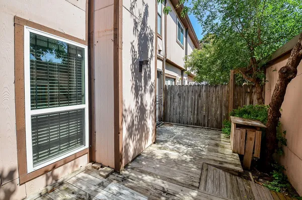 a view of backyard with wooden fence and large trees