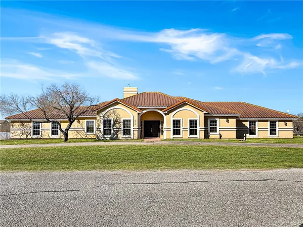 a front view of a house with a garden and trees