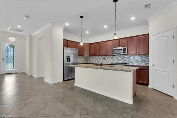 a kitchen with kitchen island granite countertop wooden cabinets and stainless steel appliances