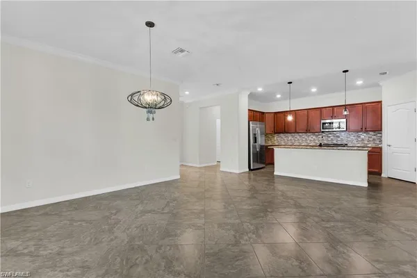 a large kitchen with cabinets and a chandelier