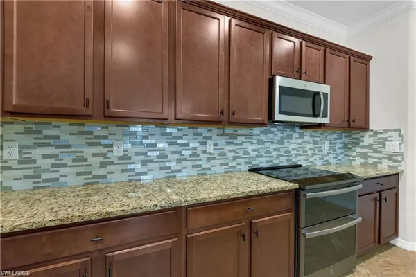 a kitchen with granite countertop stainless steel appliances a stove sink and microwave