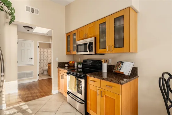 a kitchen with stainless steel appliances granite countertop a stove a sink and a microwave