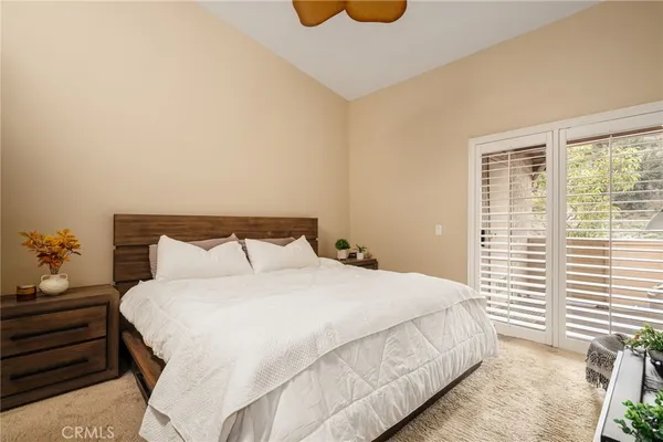 a large bed sitting in a bedroom next to a window