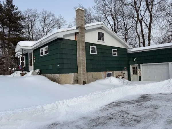 a view of a house with a yard covered in snow