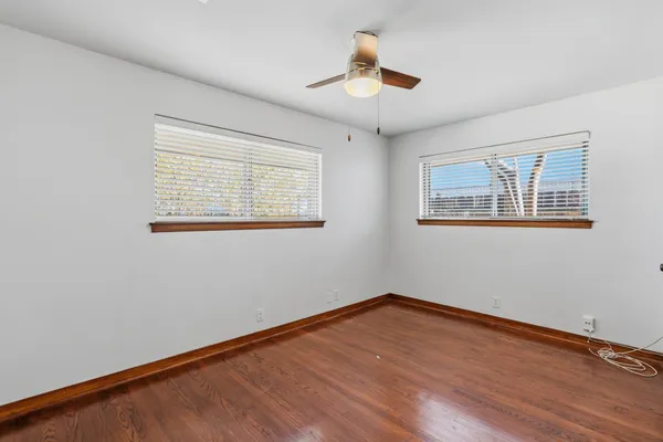 a view of empty room with wooden floor and window