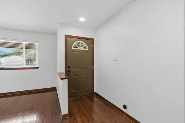 a view of hallway with window and wooden floor