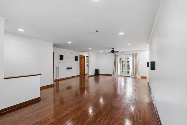 a view of empty room with wooden floor