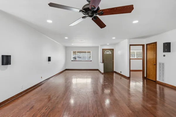 a view of an empty room with wooden floor