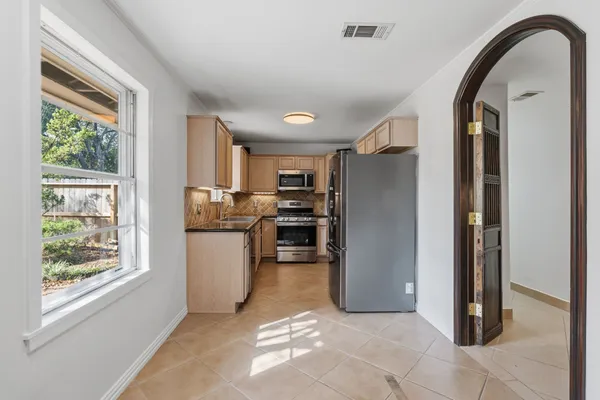 a kitchen with a refrigerator and window