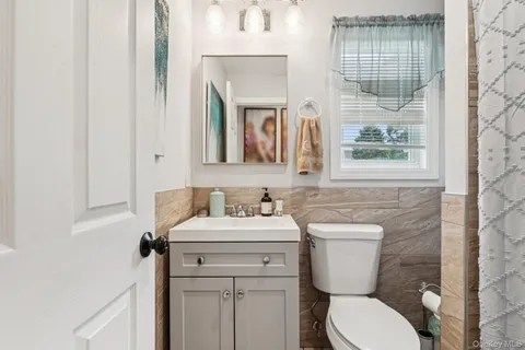 a bathroom with a toilet sink and mirror