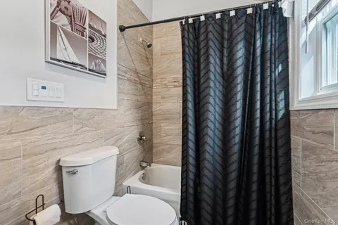 a bathroom with a toilet a sink and curtain