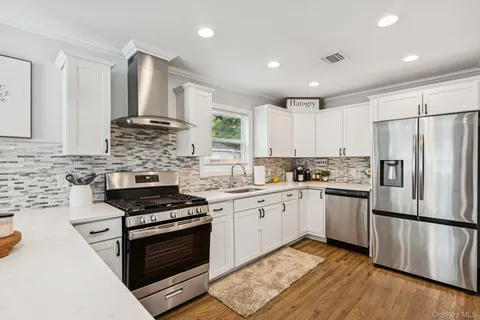a kitchen with stainless steel appliances granite countertop a stove a sink and a refrigerator