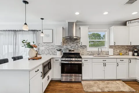 a kitchen with stainless steel appliances granite countertop a stove a sink and a refrigerator