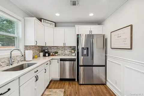 a kitchen with a refrigerator sink and cabinets
