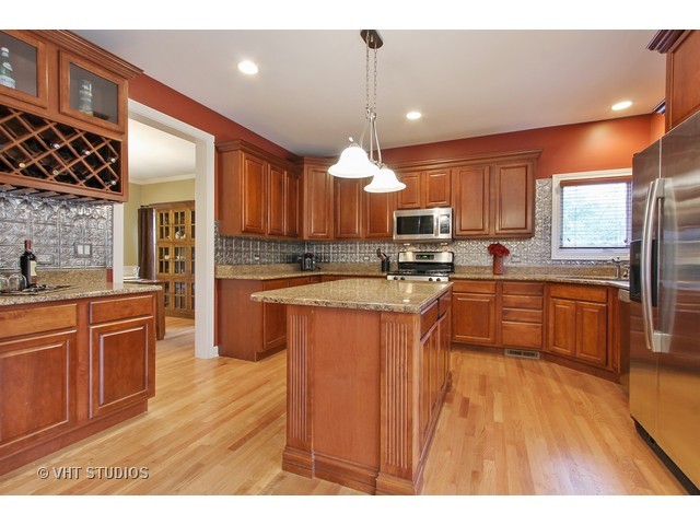 1111 Old York Road Elmhurst, IL 60126 - Photo 4 of 20 a kitchen with stainless steel appliances kitchen island granite countertop wooden floors wooden cabinets a center island and stainless steel appliances