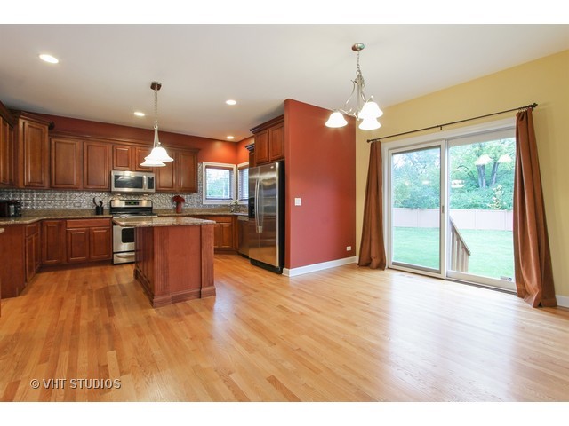 1111 Old York Road Elmhurst, IL 60126 - Photo 5 of 20 a large kitchen with stainless steel appliances granite countertop a stove top oven a sink dishwasher with a dining table and chairs