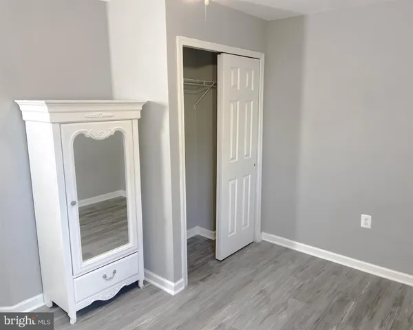 an entryway with wooden floor and cabinet