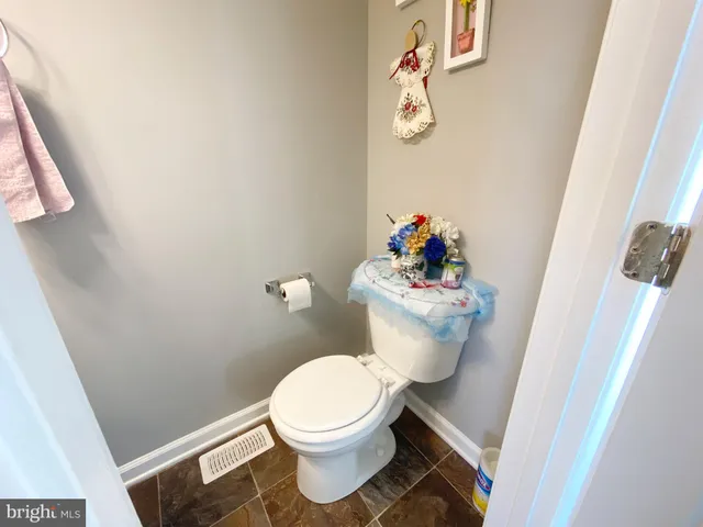 a white toilet sitting next to a white sink and vanity