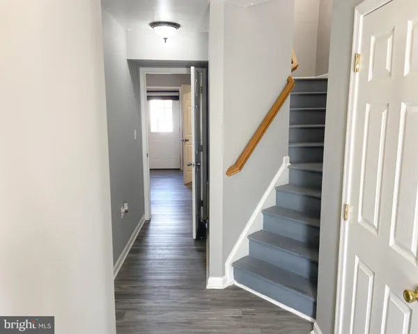 a view of a hallway with wooden floor and entryway