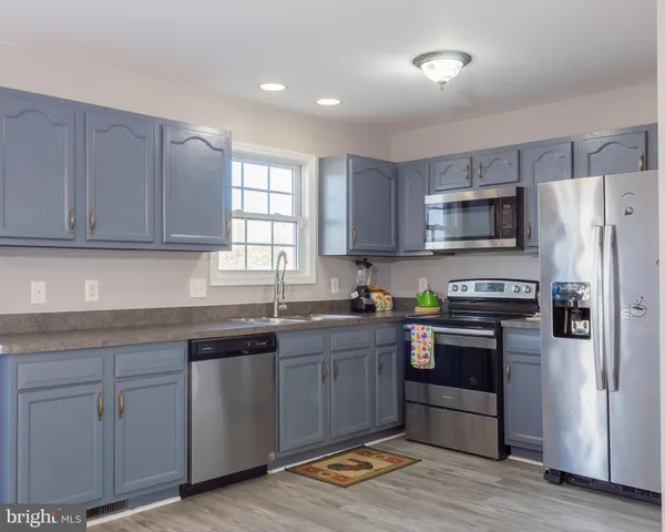 a kitchen with stainless steel appliances granite countertop a stove a sink and a refrigerator