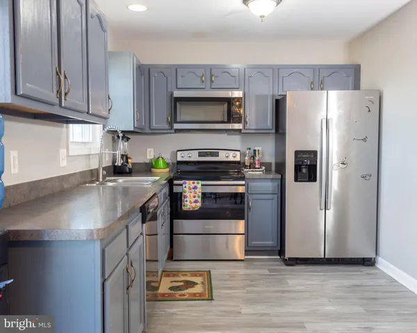 a kitchen with stainless steel appliances granite countertop a refrigerator stove and sink