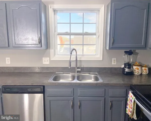 a kitchen with sink a window and cabinets