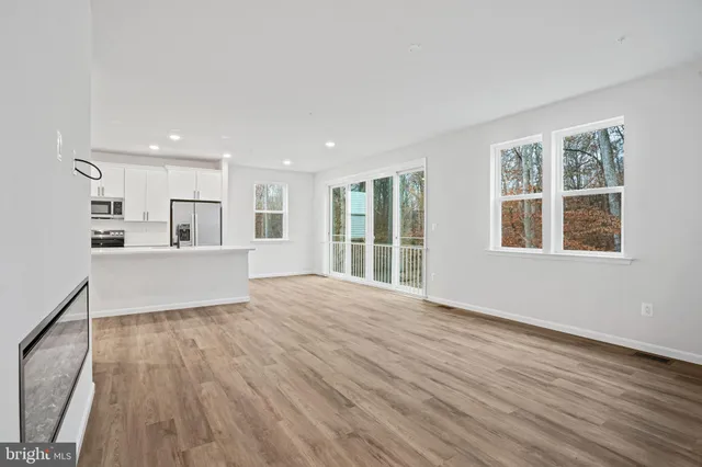 a view of a kitchen with wooden floor and a window