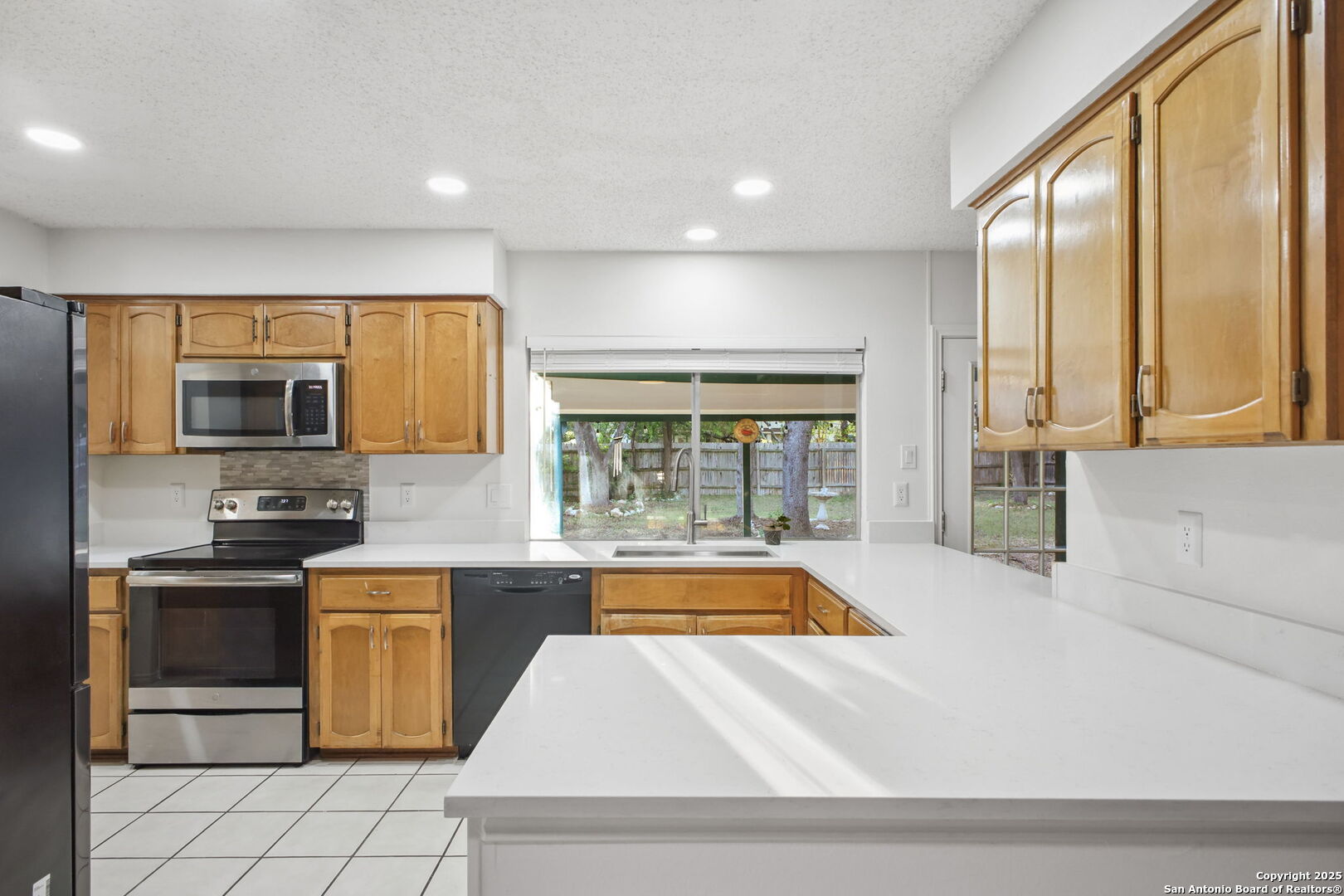 15319 Pebble Path San Antonio, TX 78232 - Photo 11 of 29 a kitchen with stainless steel appliances granite countertop a stove a sink and a microwave