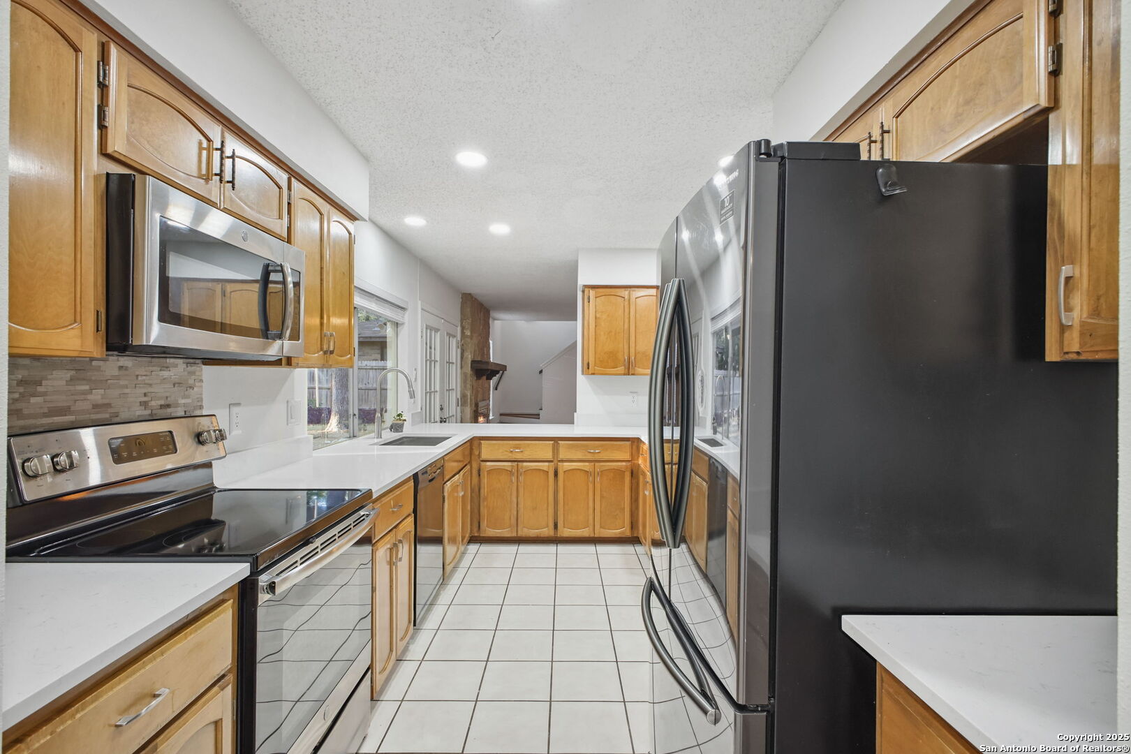 15319 Pebble Path San Antonio, TX 78232 - Photo 13 of 29 a kitchen with stainless steel appliances a refrigerator sink and microwave