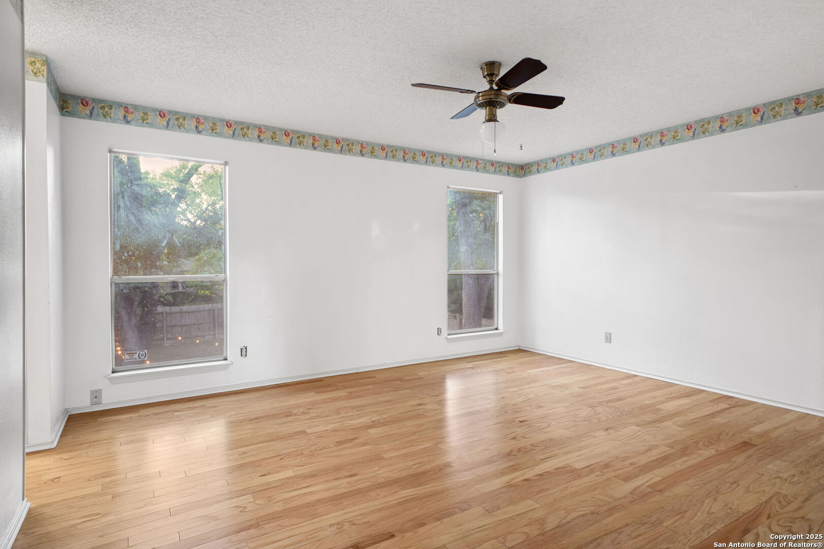 15319 Pebble Path San Antonio, TX 78232 - Photo 22 of 29 an empty room with wooden floor fan and windows
