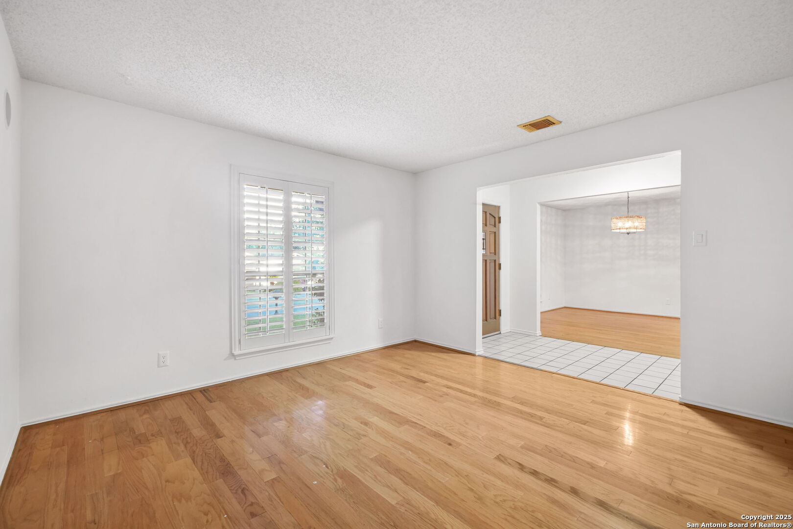 15319 Pebble Path San Antonio, TX 78232 - Photo 4 of 29 a view of an empty room with wooden floor and a window
