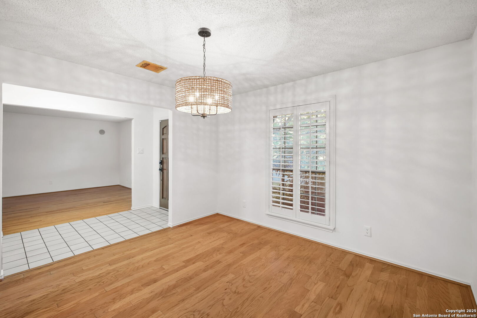 15319 Pebble Path San Antonio, TX 78232 - Photo 5 of 29 a view of an empty room with wooden floor and a window