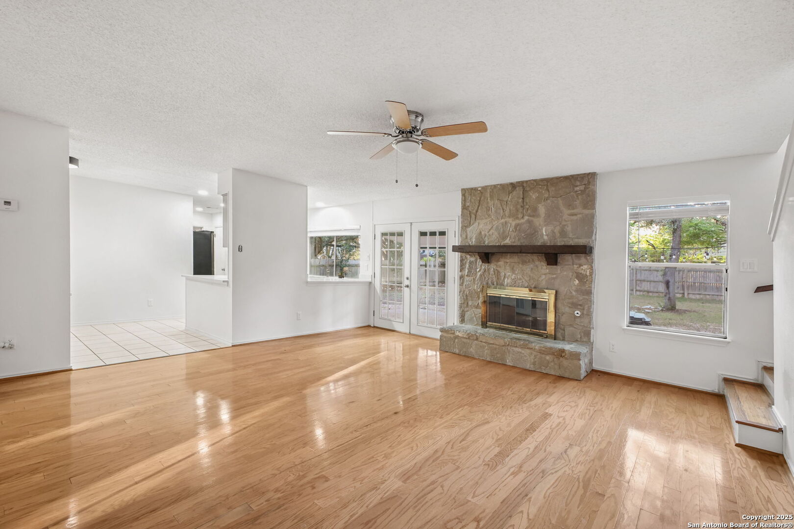 15319 Pebble Path San Antonio, TX 78232 - Photo 8 of 29 a view of a livingroom with a fireplace a ceiling fan and windows
