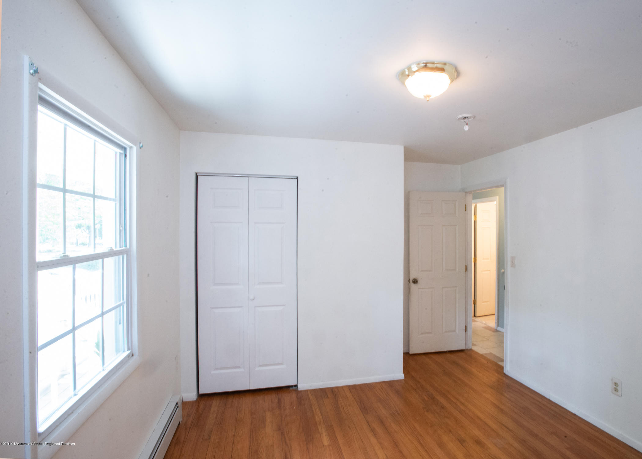 802 West Farms Road Howell, NJ 07731 - Photo 7 of 16 a view of an empty room with wooden floor and a window