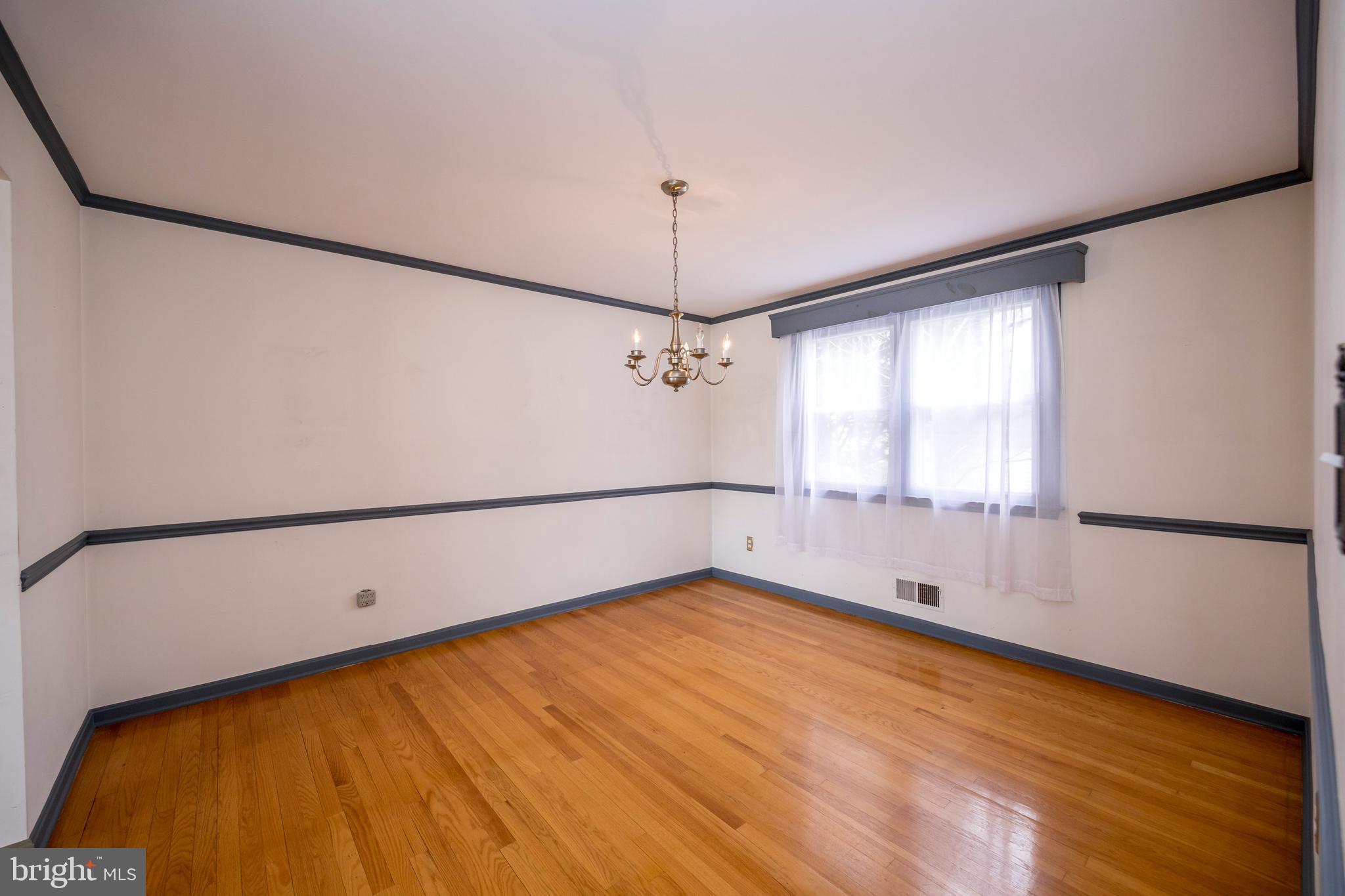 4300 Camellia Road Nottingham, MD 21236 - Photo 13 of 47 a view of an empty room with chandelier fan and wooden floor