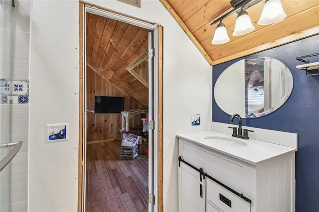 a bathroom with a granite countertop sink and a mirror