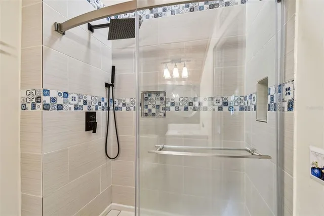 a bedroom with a bed and dresser with wooden floor