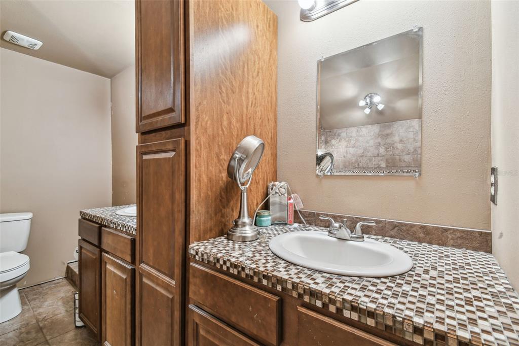 19708 Bower Road Dade City, FL 33523 - Photo 64 of 84 a bathroom with a granite countertop sink and a mirror