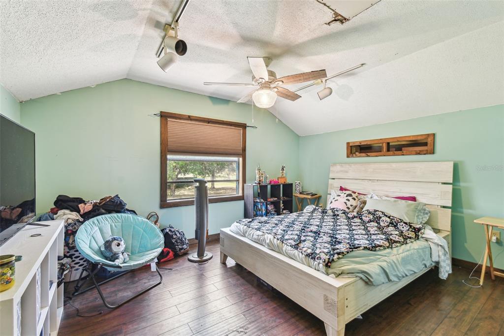 19708 Bower Road Dade City, FL 33523 - Photo 65 of 84 a bedroom with a bed and dresser with wooden floor