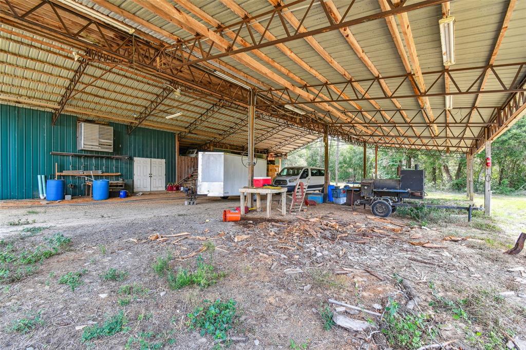 19708 Bower Road Dade City, FL 33523 - Photo 70 of 84 a view of a backyard with table and chairs under an umbrella