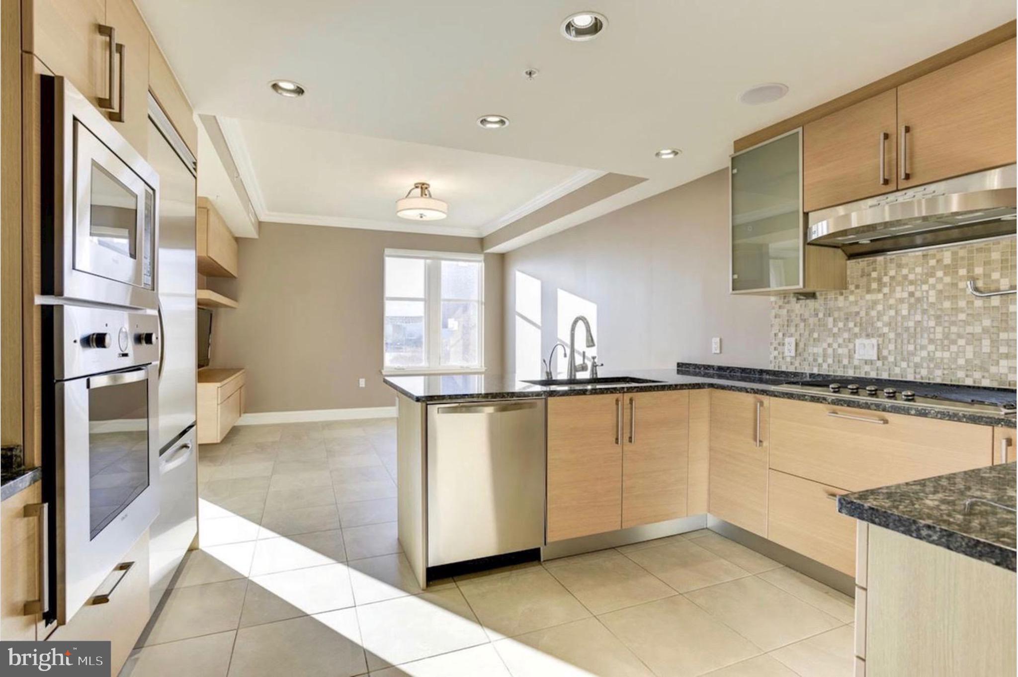 801 Key Highway, Unit 413 Baltimore, MD 21230 - Photo 15 of 58 a view of a kitchen with wooden floor and a fireplace